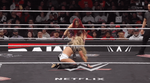two women in a wrestling ring with netflix written on the floor