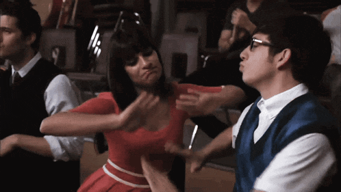 a woman in a red dress is being punched in the face by a man in a blue vest