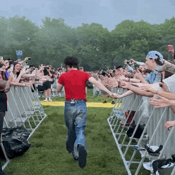 a man in a red shirt is running towards a crowd