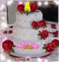 a white cake with red roses on top is sitting on a table .