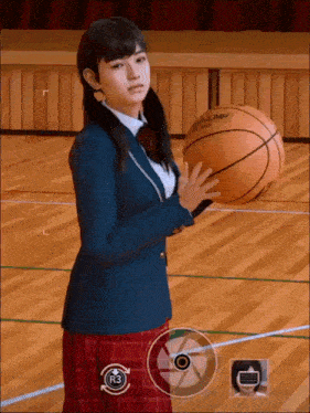 a girl in a school uniform is holding a basketball in her hand