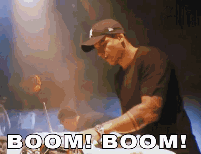 a man wearing a ny hat is playing a dj set and the words boom boom are visible