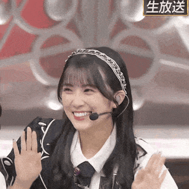a girl wearing a headband and a microphone is smiling and waving