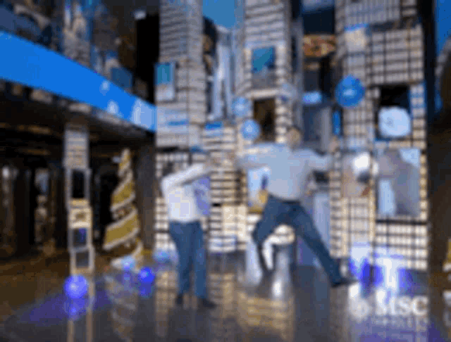 a man and a woman are jumping in the air in front of a building that says msc