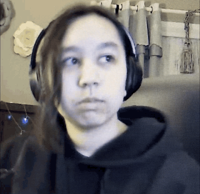 a woman wearing headphones is looking at the camera