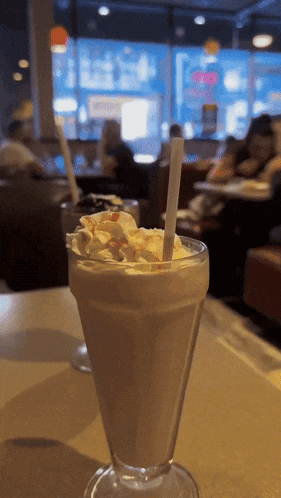 a milkshake with whipped cream and a straw