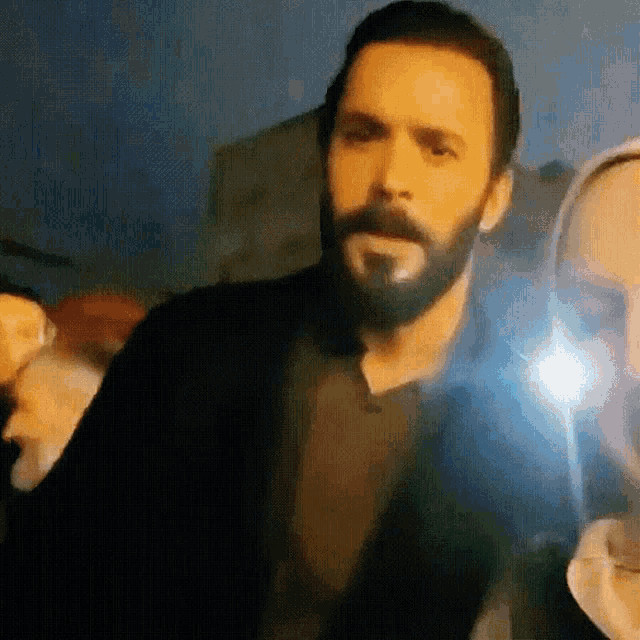 a man with a beard is standing in front of a light