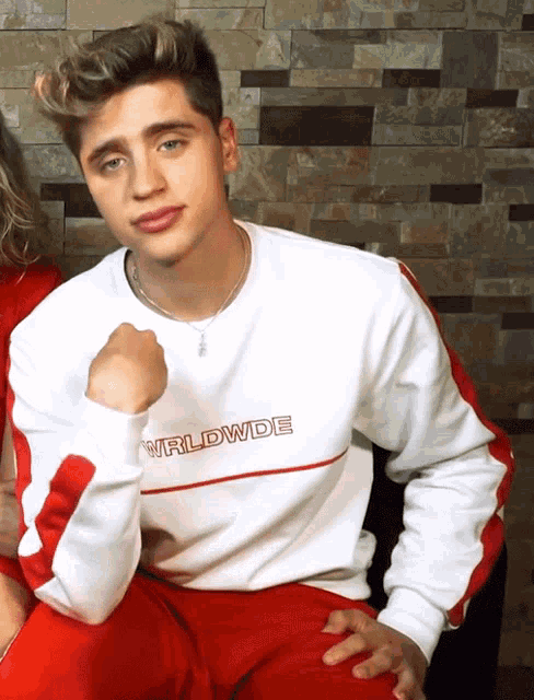 a young man wearing a white worldwide sweatshirt