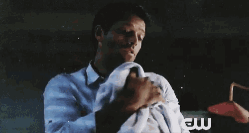 a man is holding a baby in his arms with the cw logo in the background