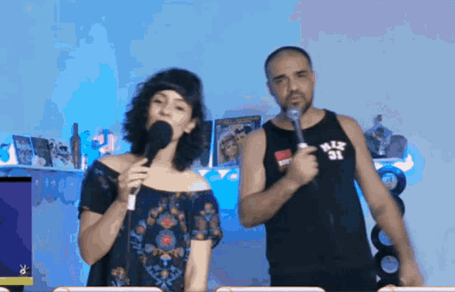 a man and a woman are singing into microphones and the man is wearing a shirt with the number 31