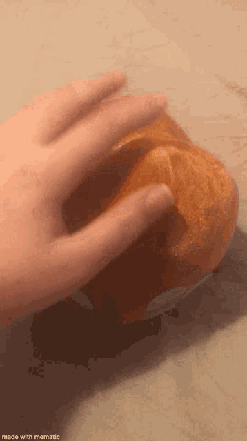 a close up of a person 's hand holding an orange .