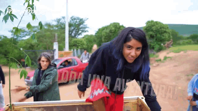 a girl with blue hair is standing in front of a sign that says " toda una aventura "
