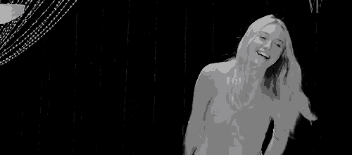 a woman is dancing in a black and white photo in front of a lamp .