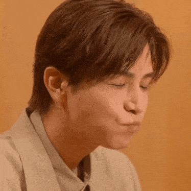 a close up of a person making a face with their eyes closed