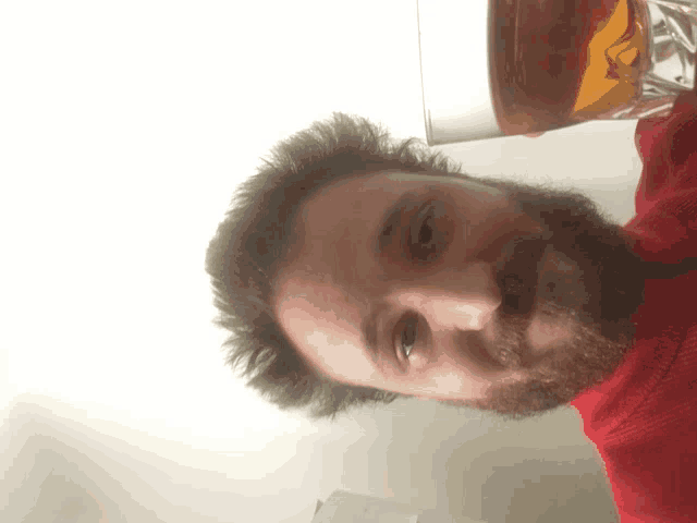 a man with a beard is holding a glass of liquid