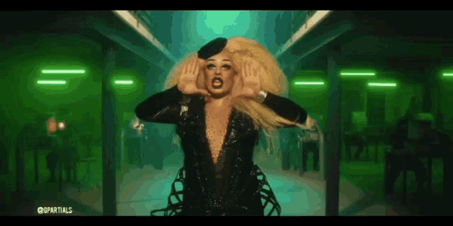 a drag queen is making a face in a green room