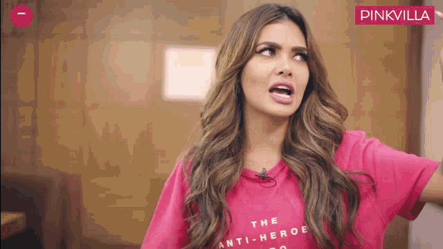 a woman wearing a pink t-shirt that says " the anti-hero "