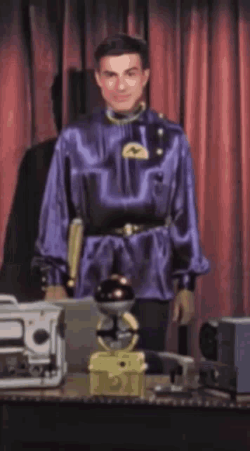 a man in a purple uniform is standing in front of a table