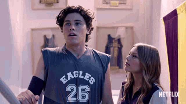 a man in an eagles jersey stands next to a girl