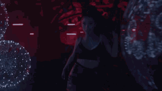 a woman stands in a dark room with a lot of lights