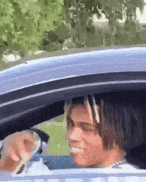a man is sitting in the driver 's seat of a car .