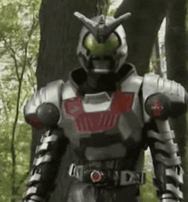 a man in a robot costume is standing in a forest .