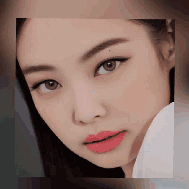 a close up of a woman 's face with red lipstick on her lips
