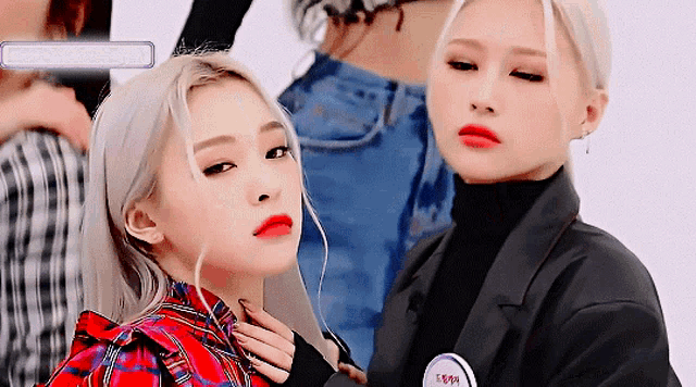 two women are standing next to each other and one has a badge that says 1999
