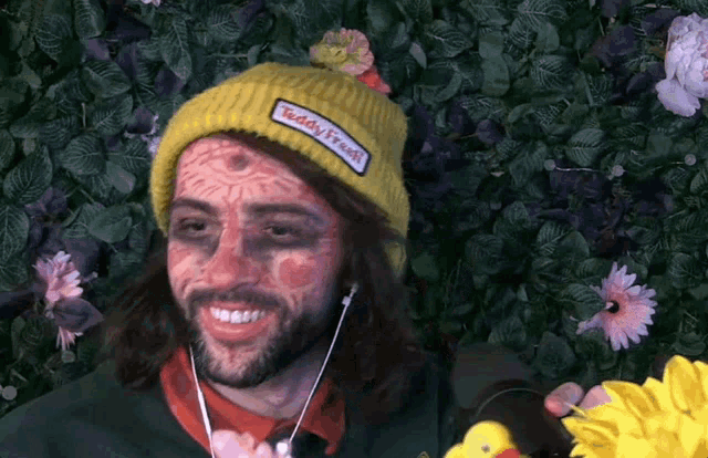 a man wearing a yellow beanie with a patch that says teddy fresh