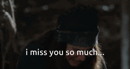 a woman sitting in a barn with the words " i miss you so much " on the bottom