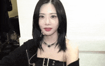 a close up of a woman wearing a black necklace and a black top .
