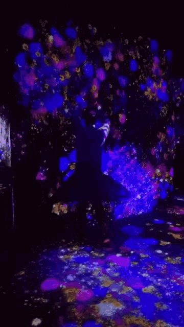 a person is standing in front of a tree with purple flowers on it
