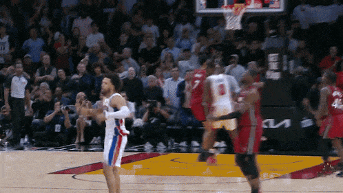 a basketball game is being played in front of a crowd and a kia sign