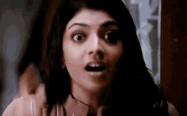 a close up of a woman 's face with her mouth open and a surprised look on her face .