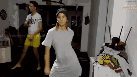 a man and a woman are dancing in front of a screen that says ' twitch '