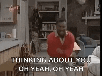 a man in a red shirt is dancing in a living room with the words `` thinking about you oh yeah oh yeah '' .
