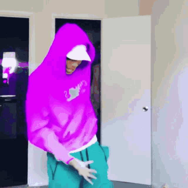a person wearing a purple hoodie and a white hat is dancing