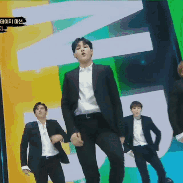 a man in a suit is dancing in front of a sign that says ' n ' on it