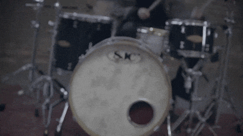 a drum set made by sjc is being played by a person