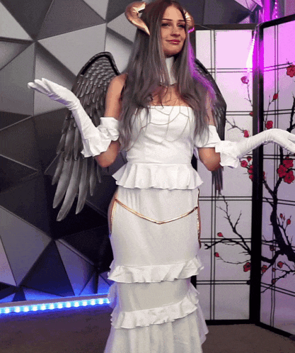 a woman in a white dress with horns and gloves