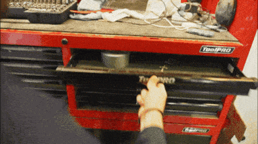 a red toolpro toolbox with a person reaching into it