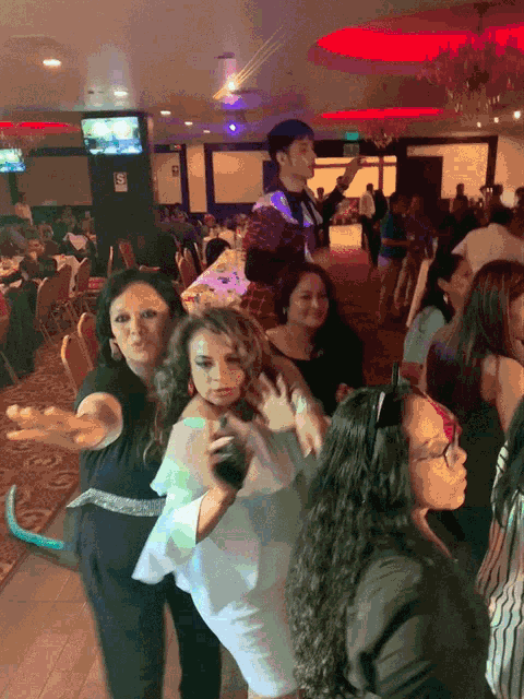 a group of people are dancing in a room with a sign that says " no smoking "