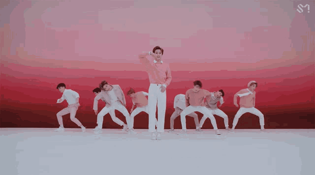 a group of young men are dancing in front of a red background with the letter s on it