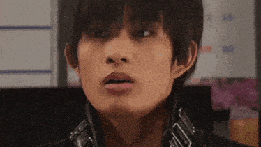 a close up of a young man 's face with a surprised look on his face