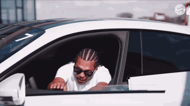 a man sitting in a car with the number 7 on the windshield