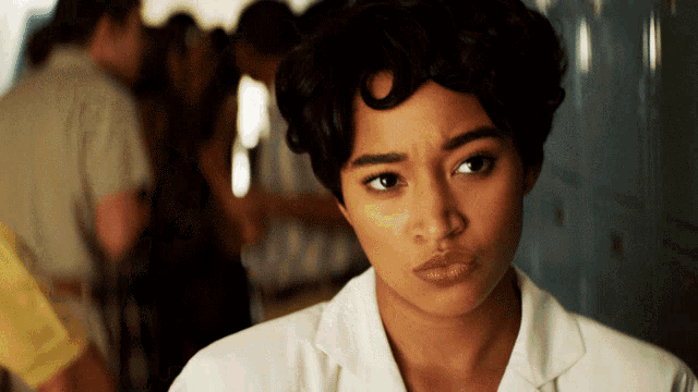 a woman in a white shirt is making a silly face