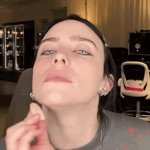 a close up of a woman 's face with a star earring on her left ear