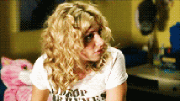 a woman with curly hair is wearing a white t-shirt that says " good girls "