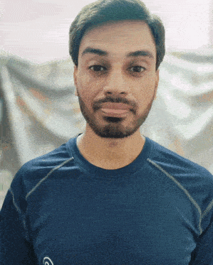 a man with a beard is wearing a blue shirt with the letter c on the front