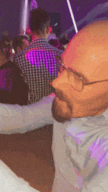 a man wearing glasses and a plaid shirt is dancing